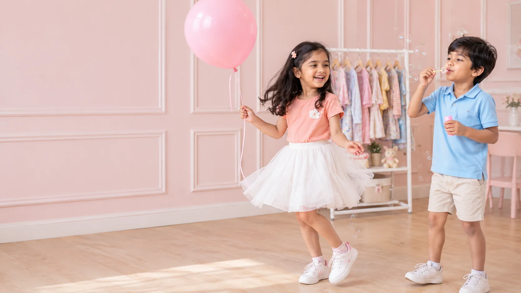 Girl with a pink balloon and boy blowing bubbles